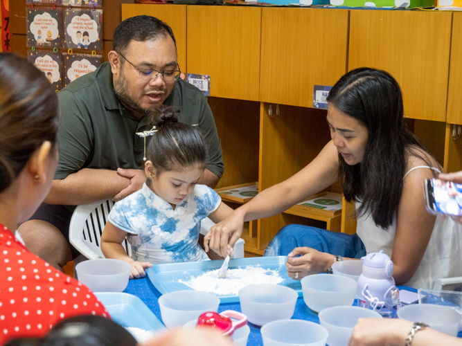 Christopher Ong looks on as his daughter Aleksia attempts to make glutinous rice balls with help from Mom Marjorie. 