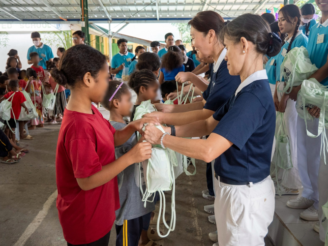 Tzu Chi volunteers and scholars help in distributing the school supplies to the students.