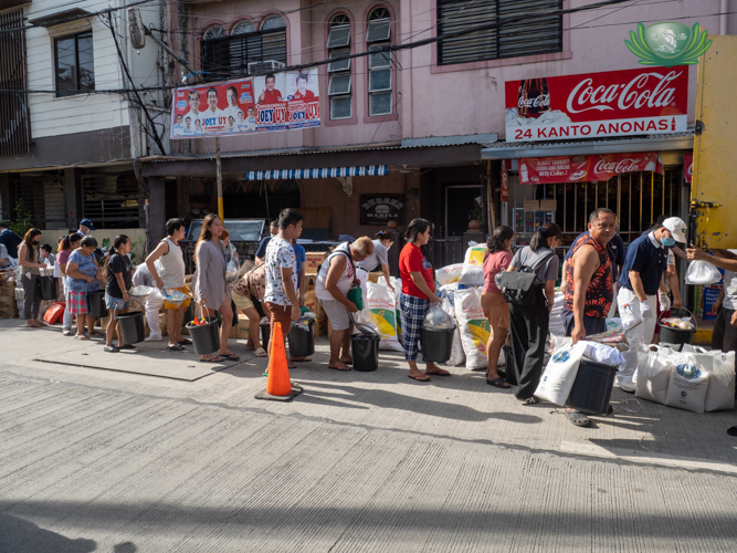 Tzu Chi volunteers help in distributing relief goods to beneficiaries.