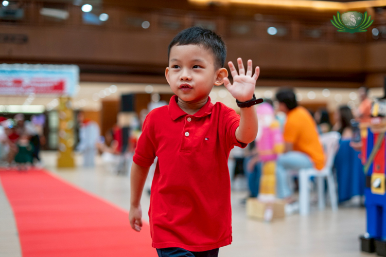 Pre-kindergarten students waved and smiled as they paraded along the red carpet.