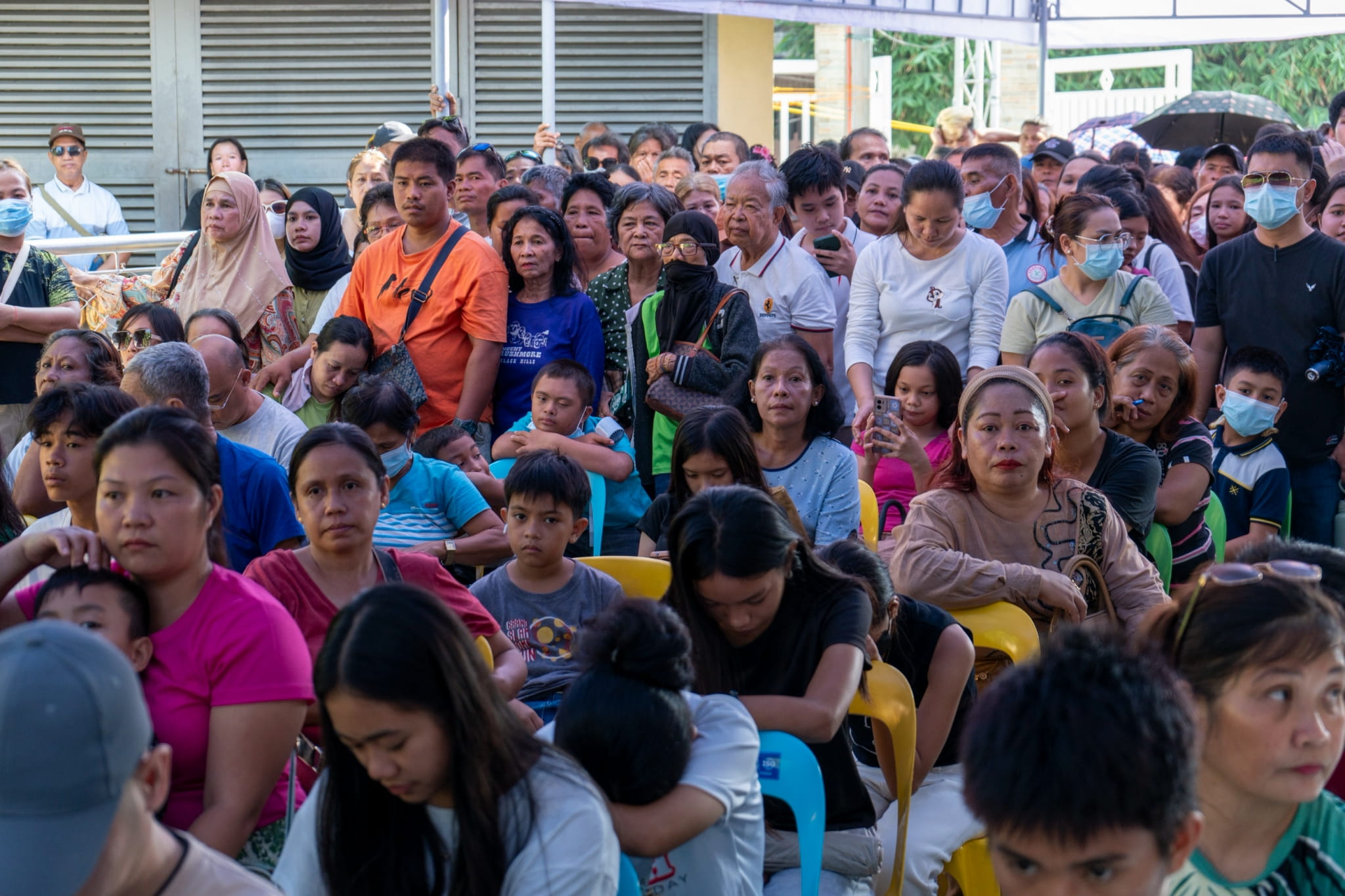 A long queue of patients forms outside the venue as registration begins.