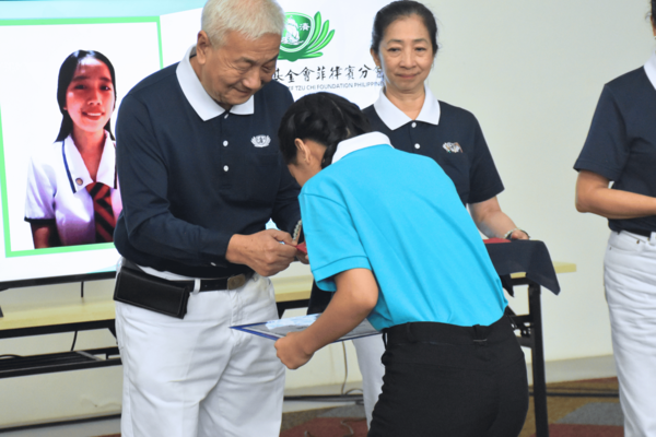 Tzu Chi scholars from Leyte Normal University receive a token of appreciation from Tzu Chi Philippines CEO Henry Yuñez.