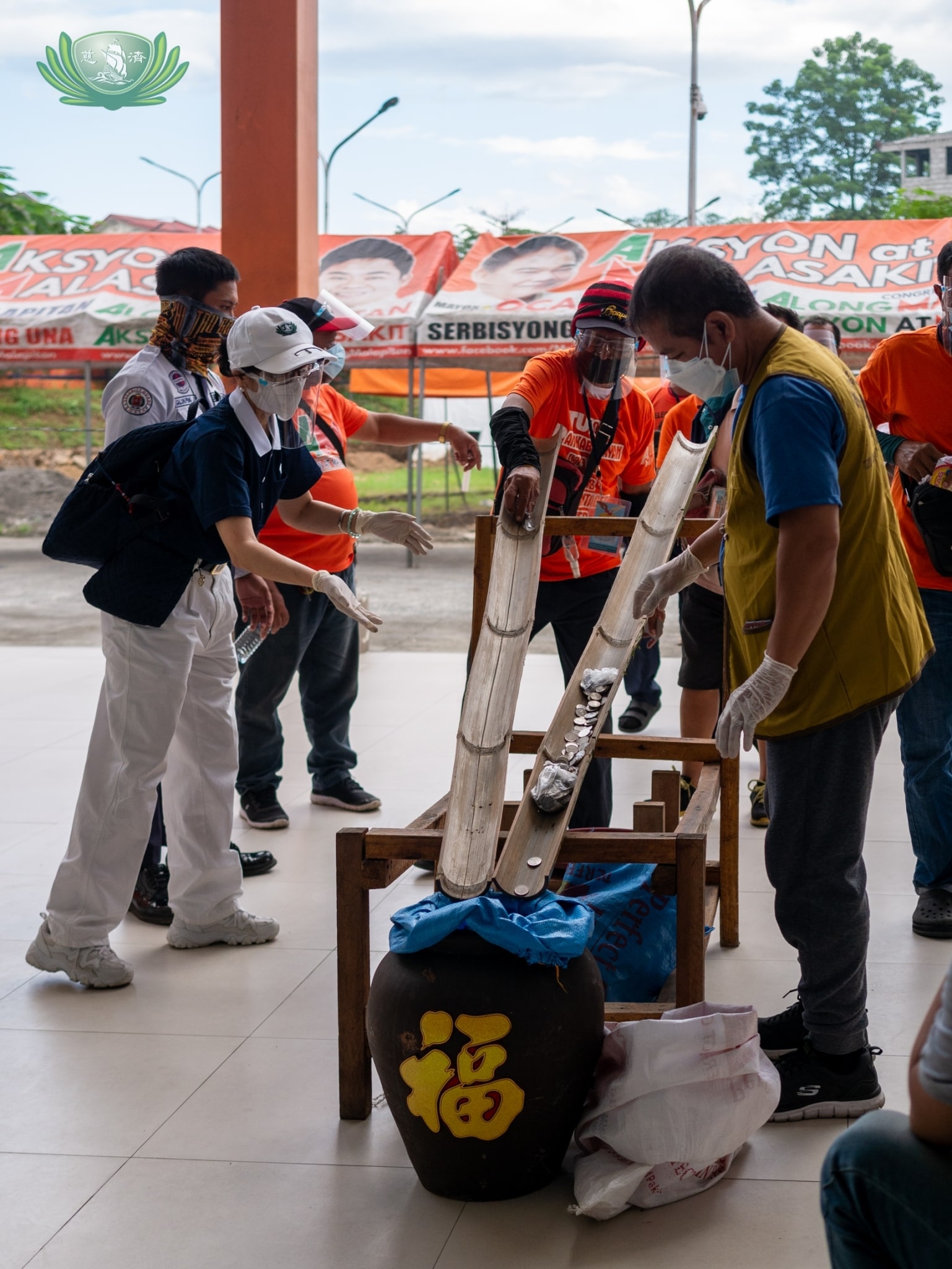 Beneficiaries place their collected pledges on a bamboo slide and into a jar. 【Photo by Daniel Lazar】