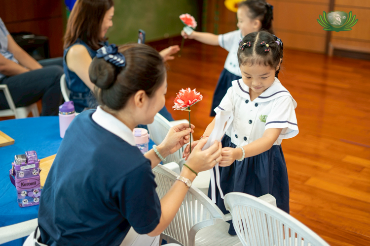 A student proudly shows her mother the tokens of gratitude she prepared.