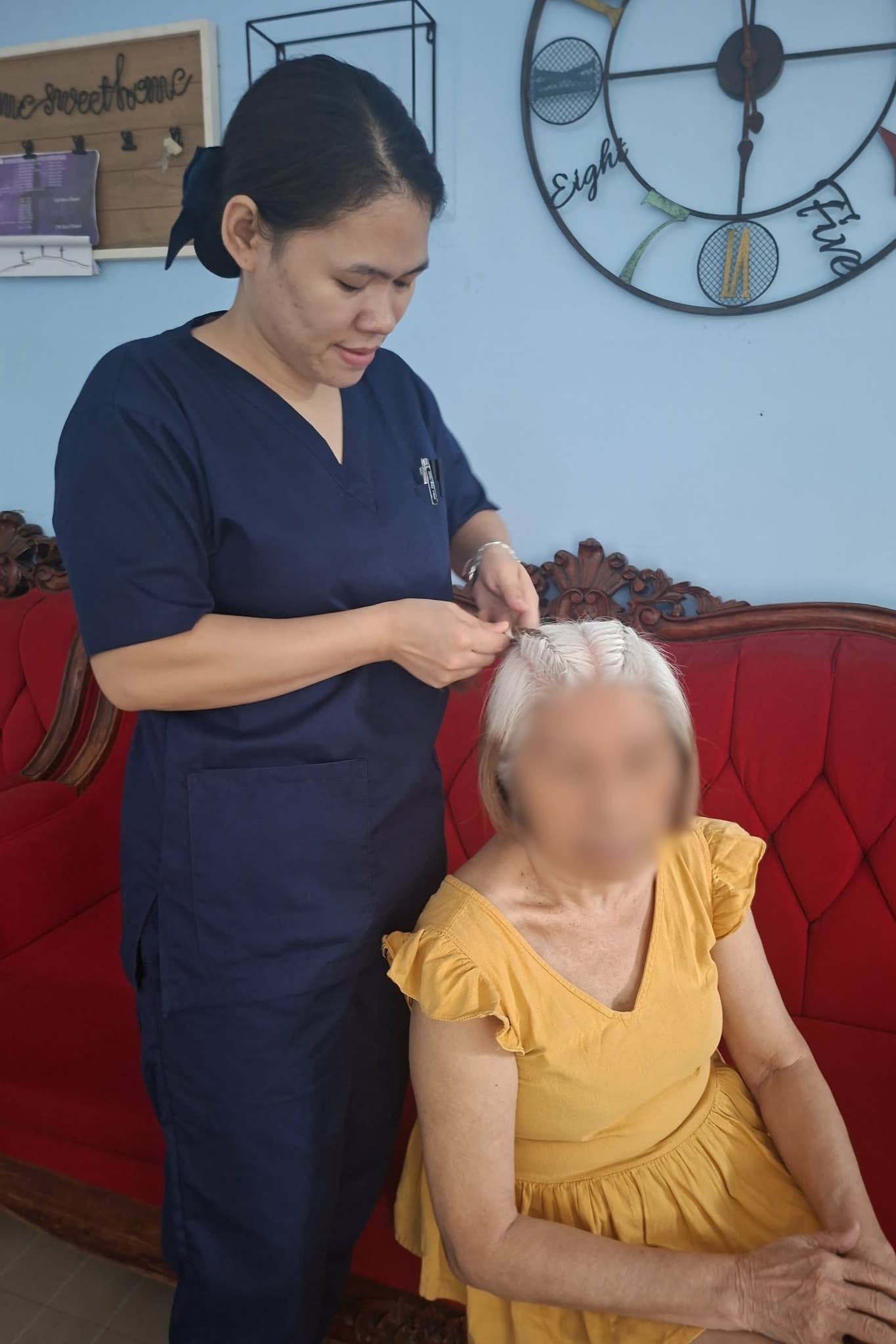 Gently braiding her patient’s hair, Renancie Abiera builds a special bond through simple acts of kindness.