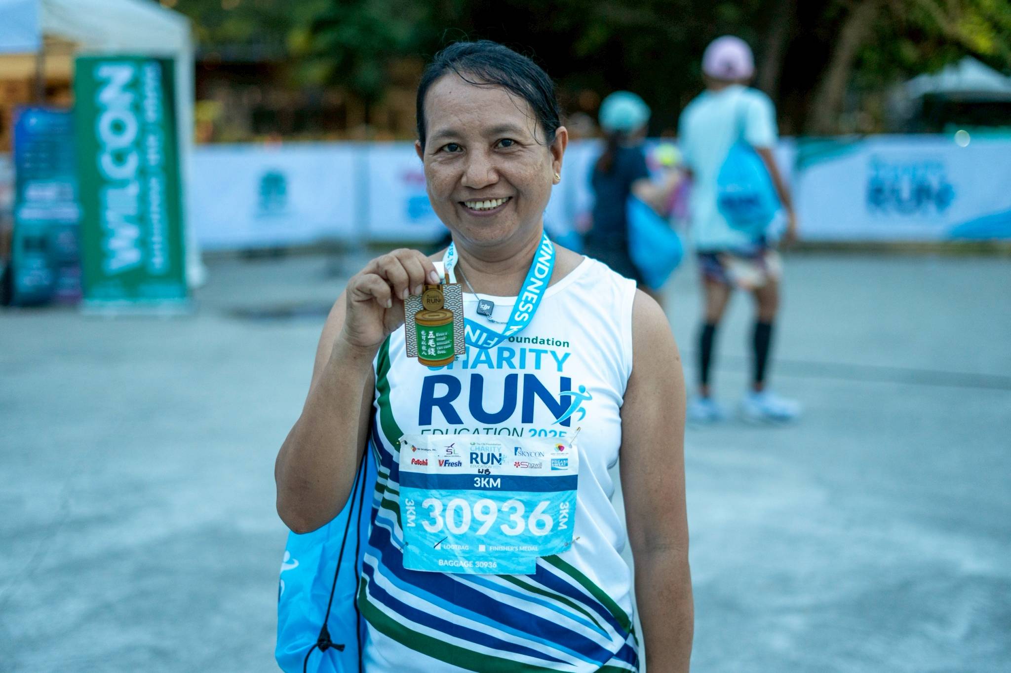 Tzu Chi Foundation staff member Evangeline Balwit, 55, proudly wears her medal after completing the 3K run.