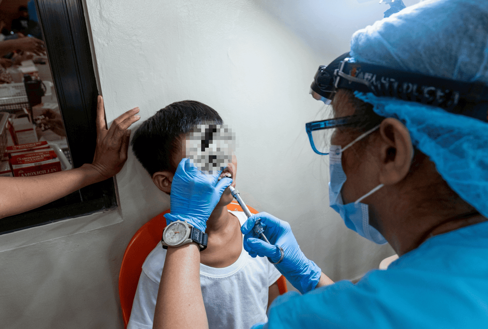 Nine-year-old Nico Jhon Dua winces as a dentist injects him with a local anesthetic before a tooth extraction. 