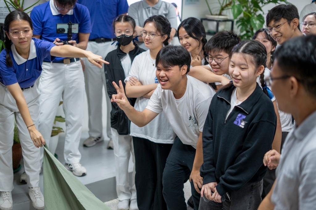 Tzu Chi Youth volunteers enjoy a fun game of guessing the person behind the cloth sheet. 