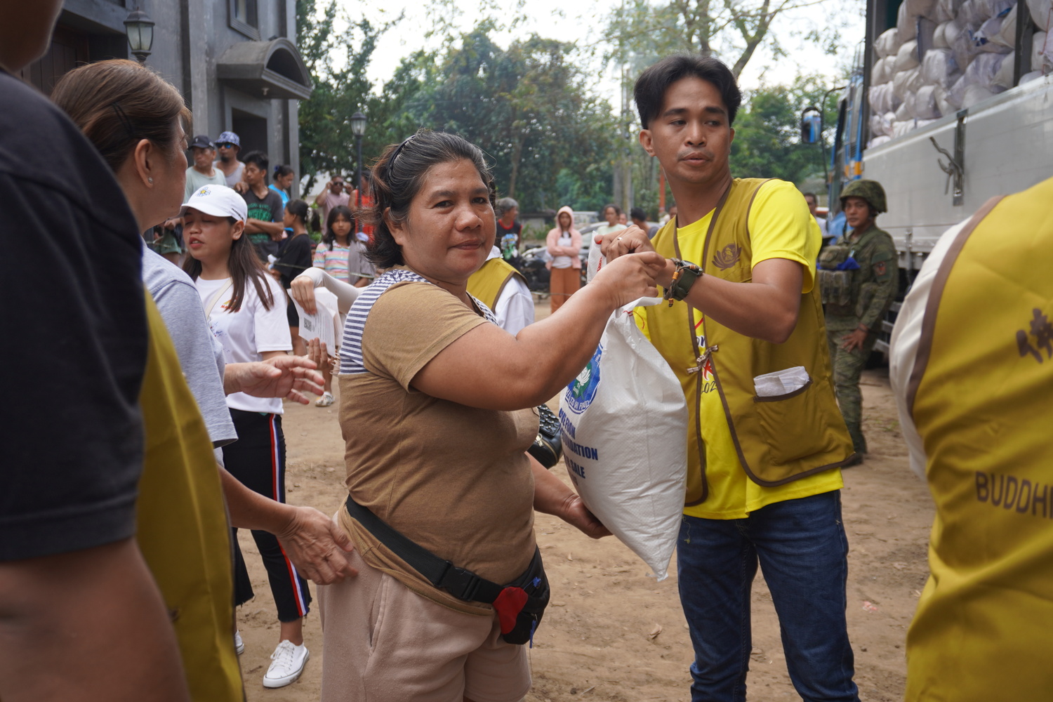 Representatives of families affected by Typhoon Kristine (Trami) claim their 10-kilogram sack of rice.