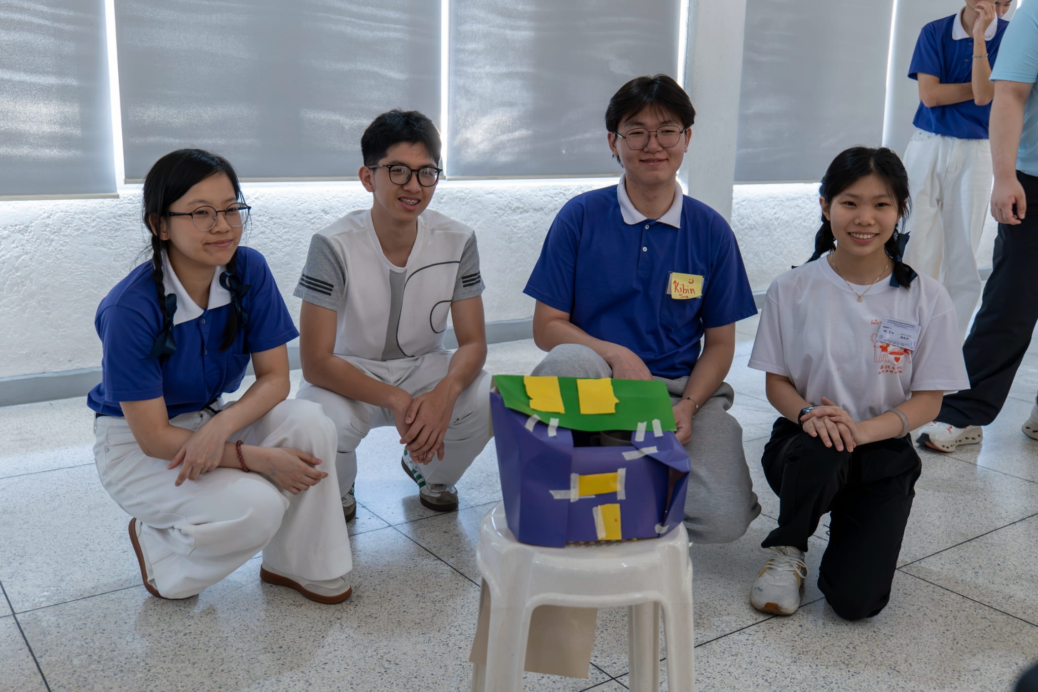 Groupmates gather around their creation in the team effort “Survival Game.”