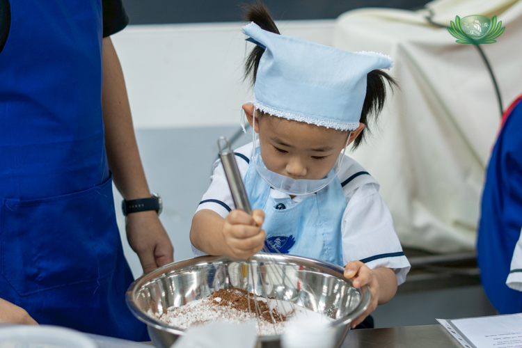 A preschooler enjoys mixing the dry ingredients for the cupcake batter.
