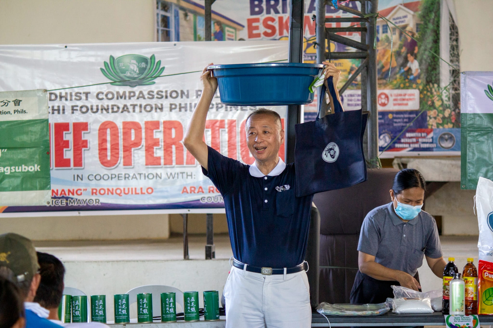 Tzu Chi volunteer Luis Diamante shows a water basin that beneficiaries can use to wash clothes and clean belongings once they return home after the floods.