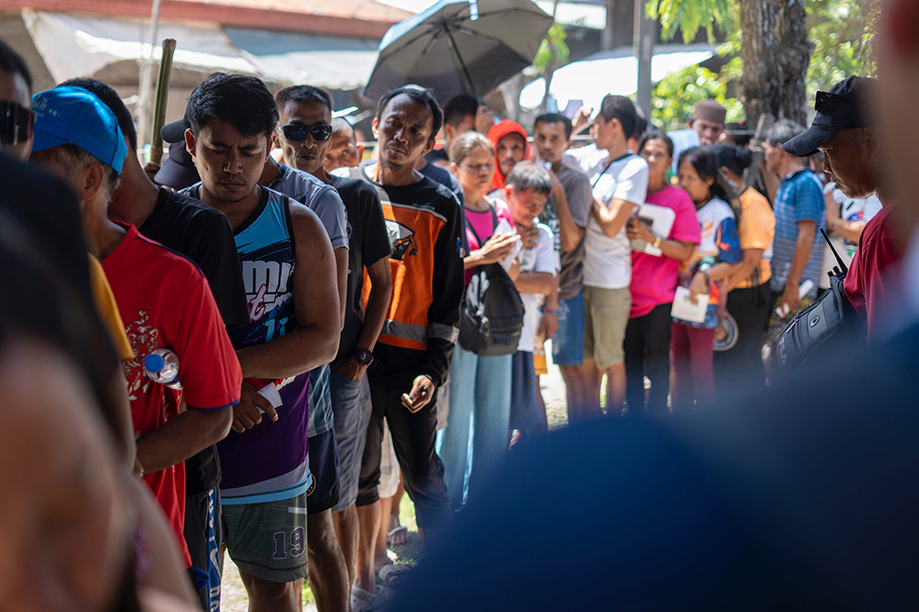 Families from Butulan, Jose Abad Santos, patiently wait in line to receive their relief claim stub. 