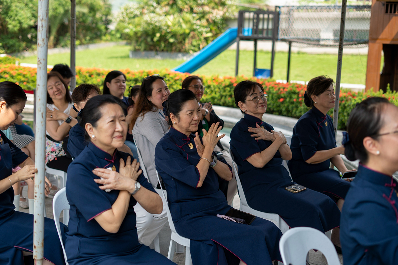 Tzu Chi volunteers and guests perform the signed song from their seats. 