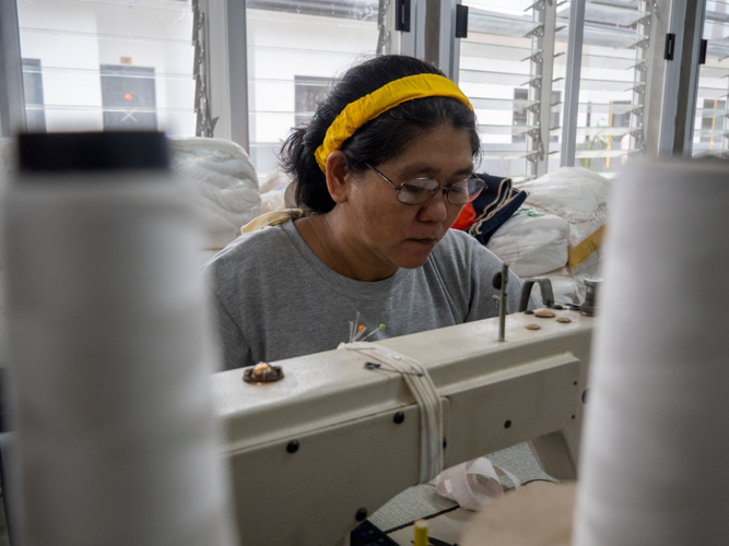 A seamstress works on sewing garters for underwear at the livelihood center.