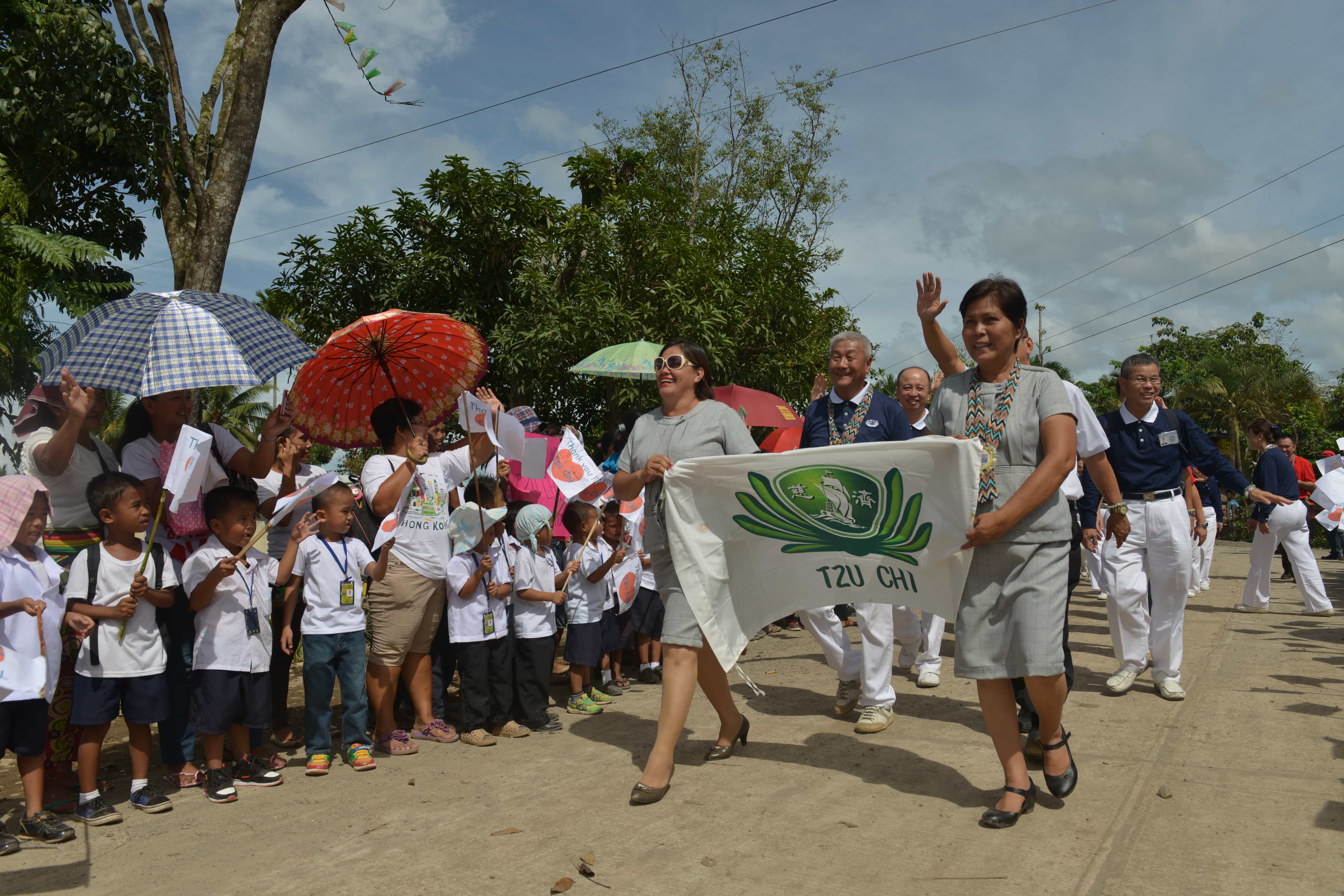 Tzu Chi volunteers are all smiles as Mangayon Elementary School students and faculty warmly welcome them during the turnover ceremony of their rebuilt school on December 1, 2014.