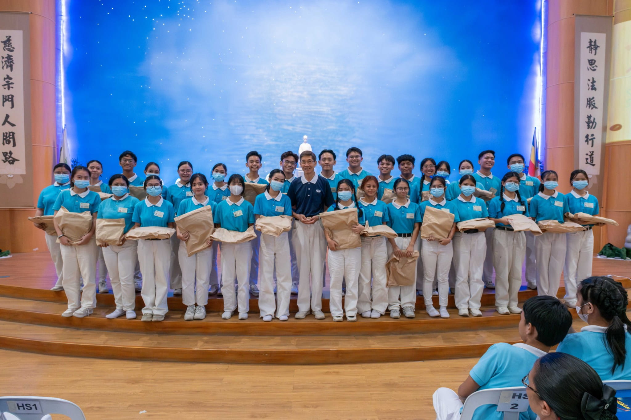 Scholars celebrating their birthday in October receive gifts distributed by Tzu Chi volunteer Johnny Cheng (center).