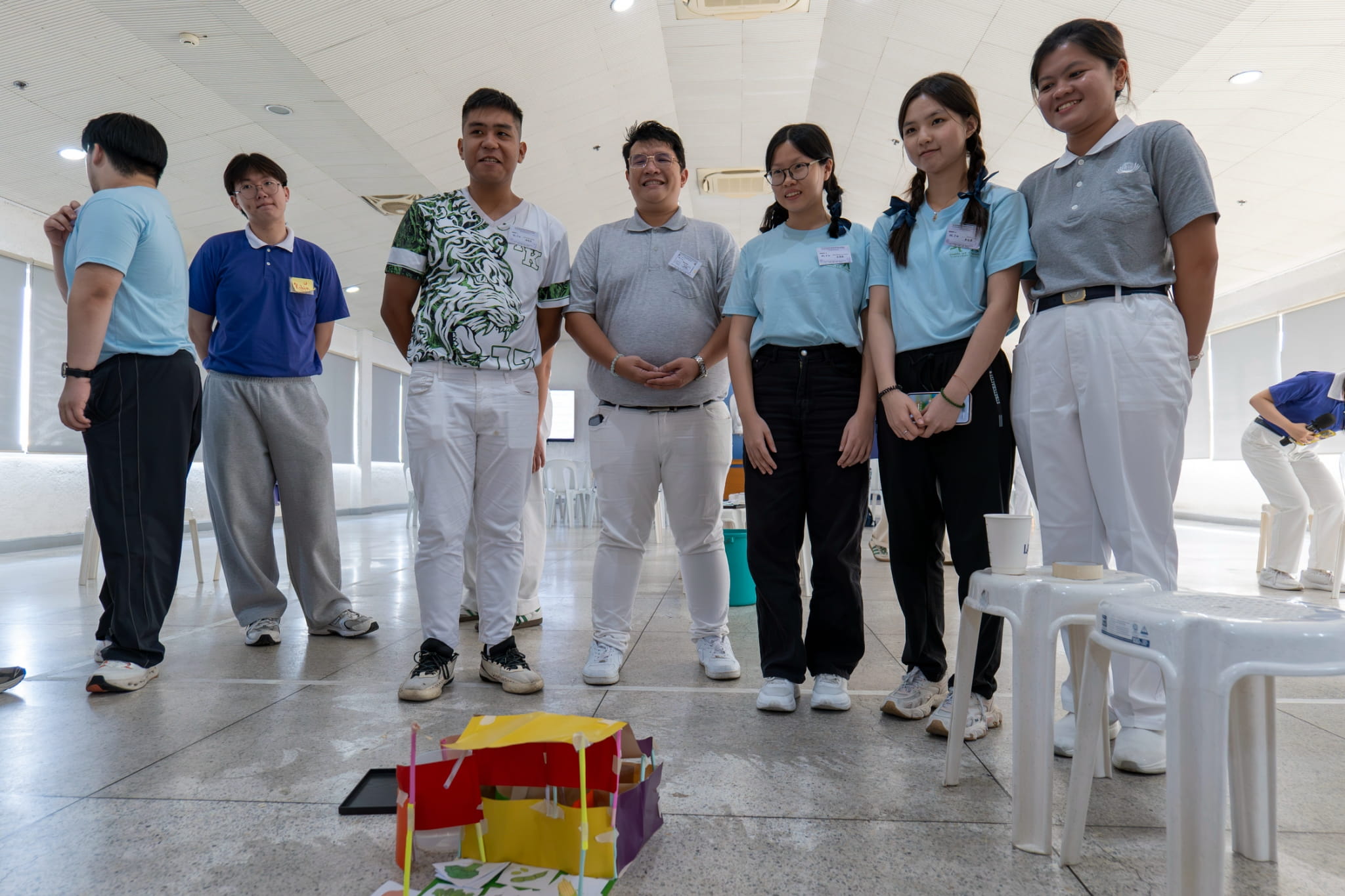 Groupmates gather around their creation in the team effort “Survival Game.”