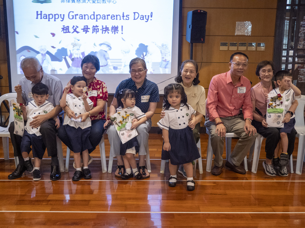 Grandparents happily take a photo together after receiving handmade gifts.