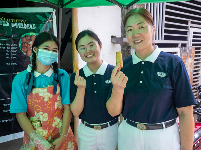 Tzu Chi volunteers) along with Mikaela Tuazon (left) proudly show the Vegan Shanghai before tasting them. 