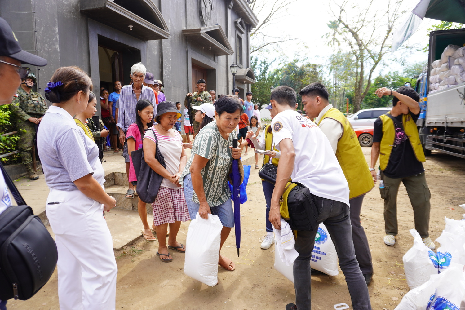 Representatives of families affected by Typhoon Kristine (Trami) claim their 10-kilogram sack of rice.