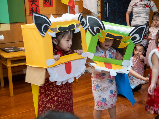 Preschoolers try their hand at lion dancing using the lion headdresses they made themselves.