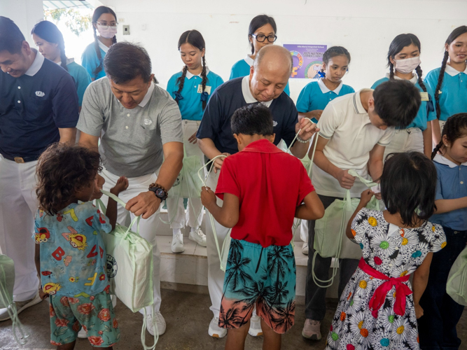 Tzu Chi volunteers are happy to give these bags of school supplies to the students.