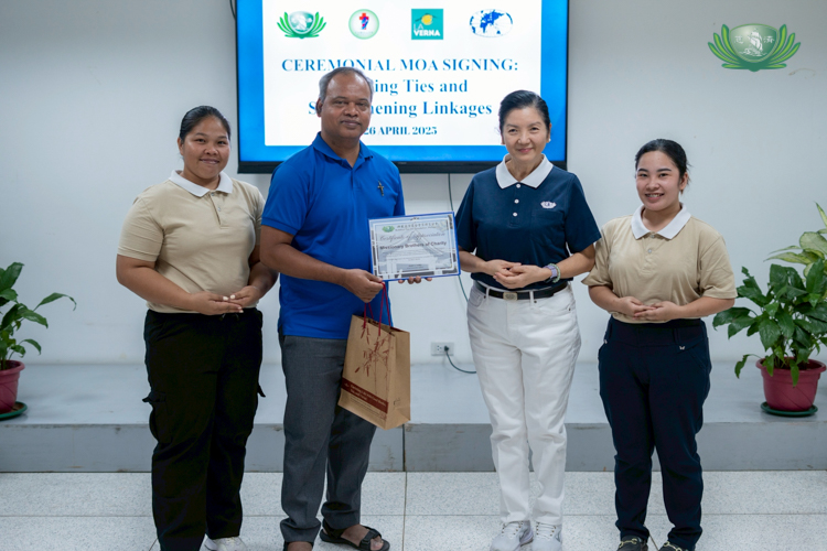 Flanked by caregiver scholars Rhea Amilano (first from left) and Esmeralda Daganaso (first from right), Bro. Abinash Minz of the Mission of Charity Brothers receives tokens of appreciation from Tzu Chi Education Committee Head Rosa So.