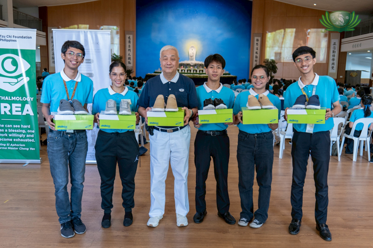 In the afternoon, scholars returned to the Jing Si Auditorium to each receive a pair sneakers from Shubizz. Tzu Chi Philippines CEO Henry Yuñez (third from left) joins scholars as they show off the brand’s different styles.