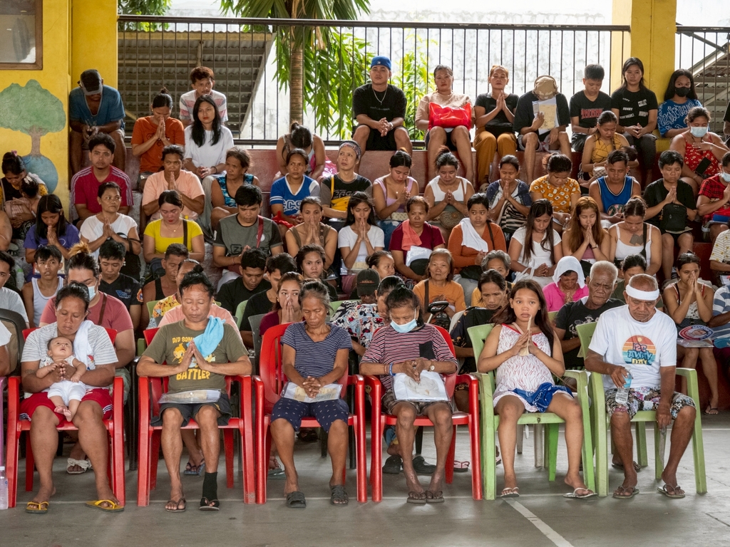 Beneficiaries pray for a world free of disasters.