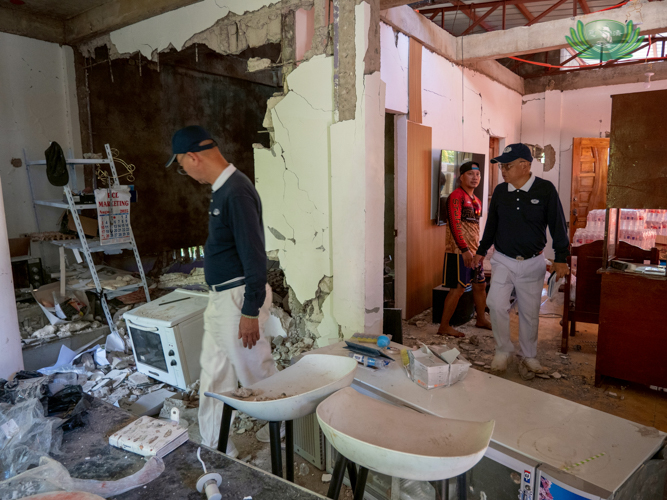 Volunteers walk through a home in the aftermath of the violent September 30 quake.