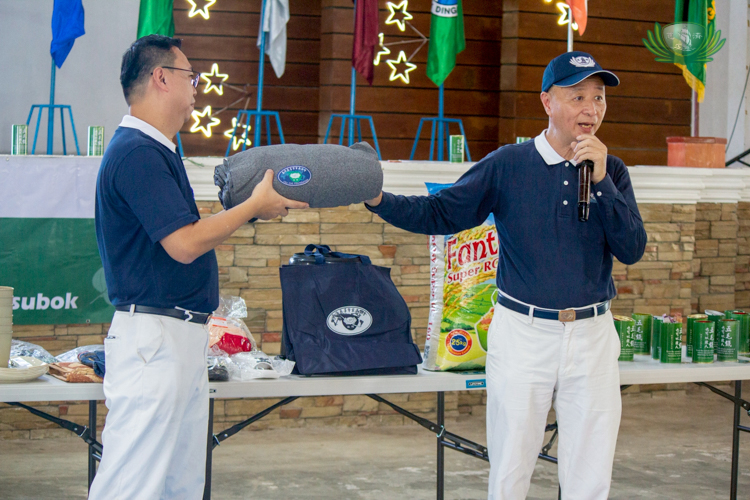 Volunteers Wilson Hung (left) and Luis Diamante present the relief packages, which include sleeping necessities, kitchen essentials, and 25 kg of rice for each household.