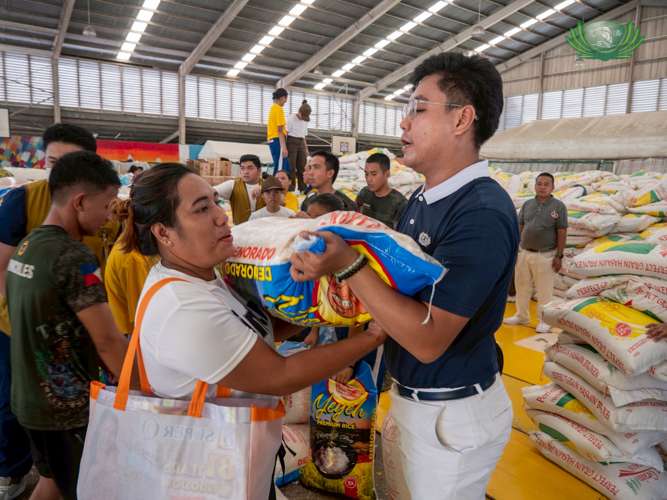 Tzu Chi Zamboanga volunteer Dhing Abdulaup distributes a sack of rice to a beneficiary. 