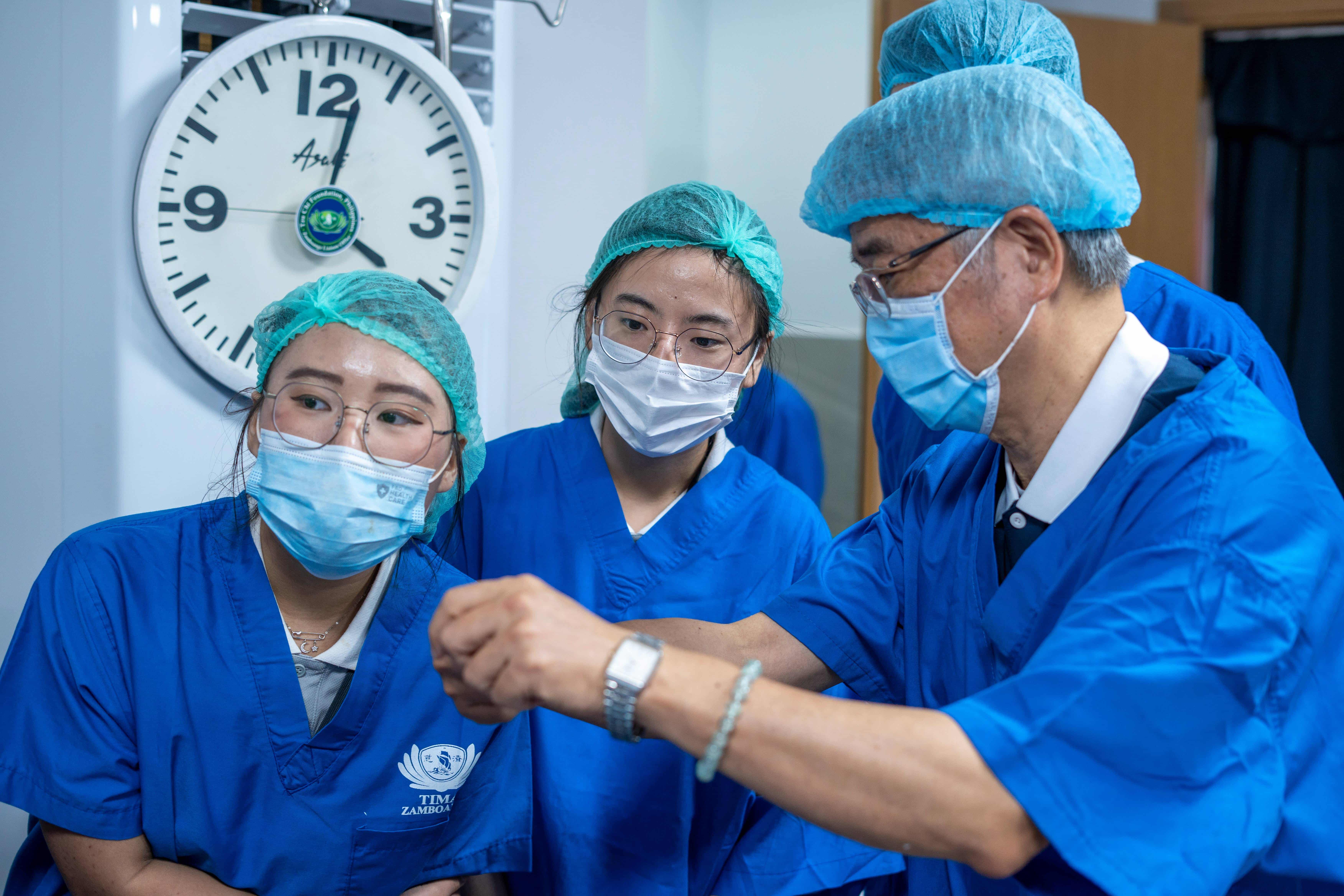 Low Xin Yu (center) closely observes procedures inside the surgery room. 
