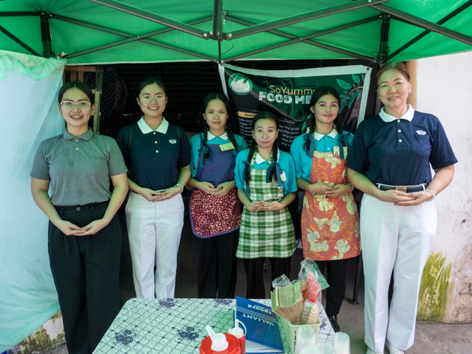 Tzu Chi volunteers, a staff member, and three Pampanga scholars smile for a group photo.