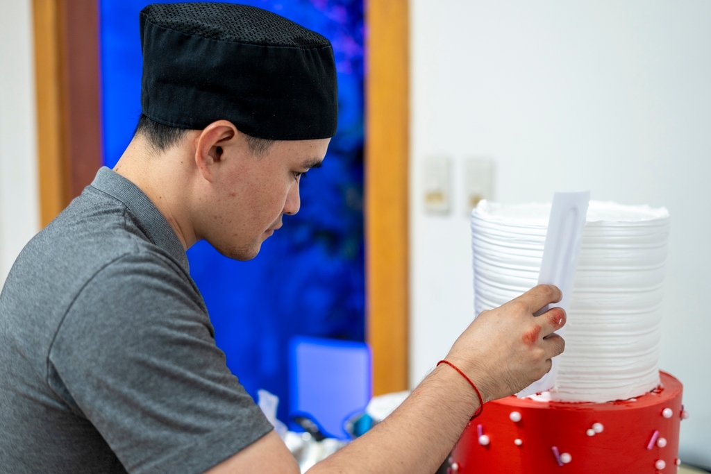 For Adrian Neil Ang, putting together the three layers of heavy cakes was a challenge. He transported the layers separately from the bakery in Synergy Hall to the Jing Si Hall, where he assembled and decorated them backstage before the big reveal.