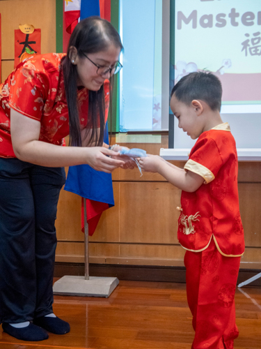 Tzu Chi Great Love Preschool Philippines Directress Jane Sy presents each preschooler with a token. 