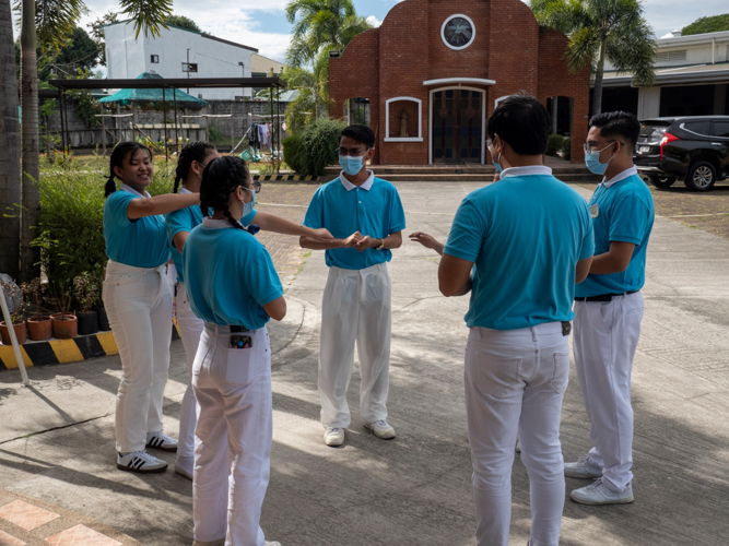 Tzu Chi scholars engage residents in “I wanna be a tutubi,” a game where participants pass a small stone while others try to guess where it is.