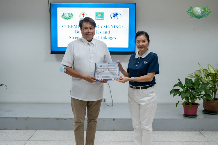 La Verna Aged Care and Dementia Village geriatric specialist Dr. Miguel Ramos Jr. receives a certificate of appreciation from Tzu Chi Education Committee Head Rosa So.