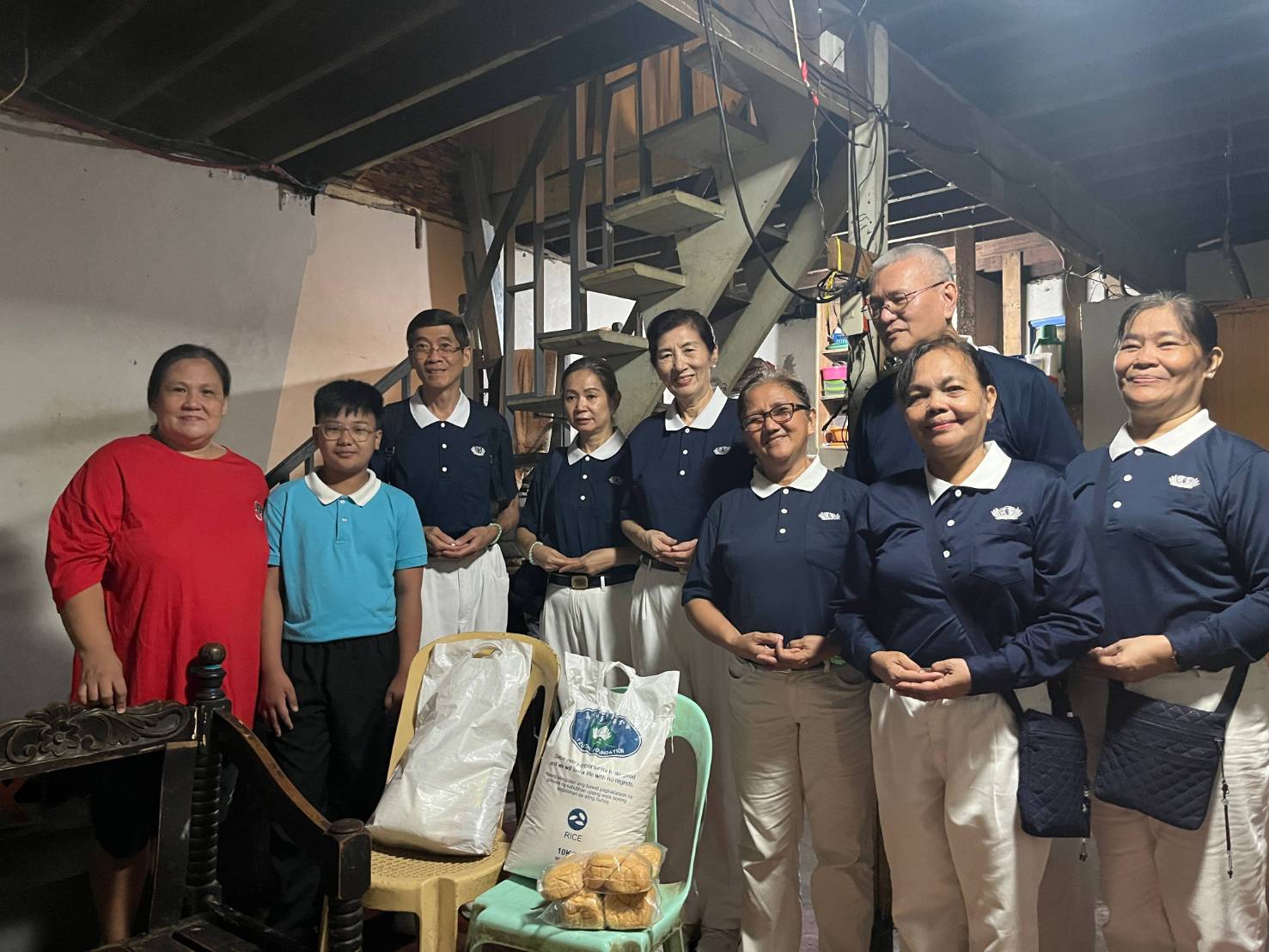 At the home of Tzu Chi scholar Ramil Cantano (second from left), volunteers delivered basic provisions, bread, and five GI sheets.