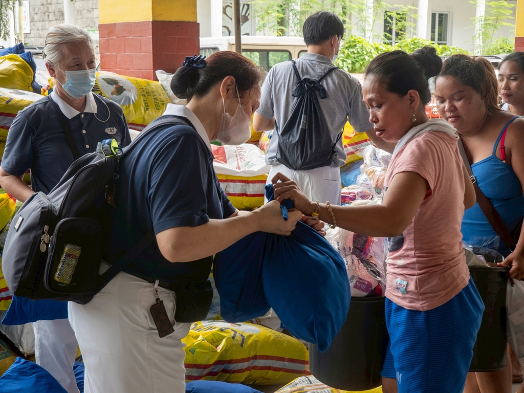 Beneficiary Jessica Esmeral receives relief items.