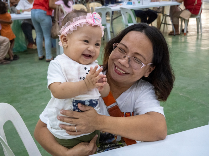 A happy child smiles while being assessed during the medical mission.