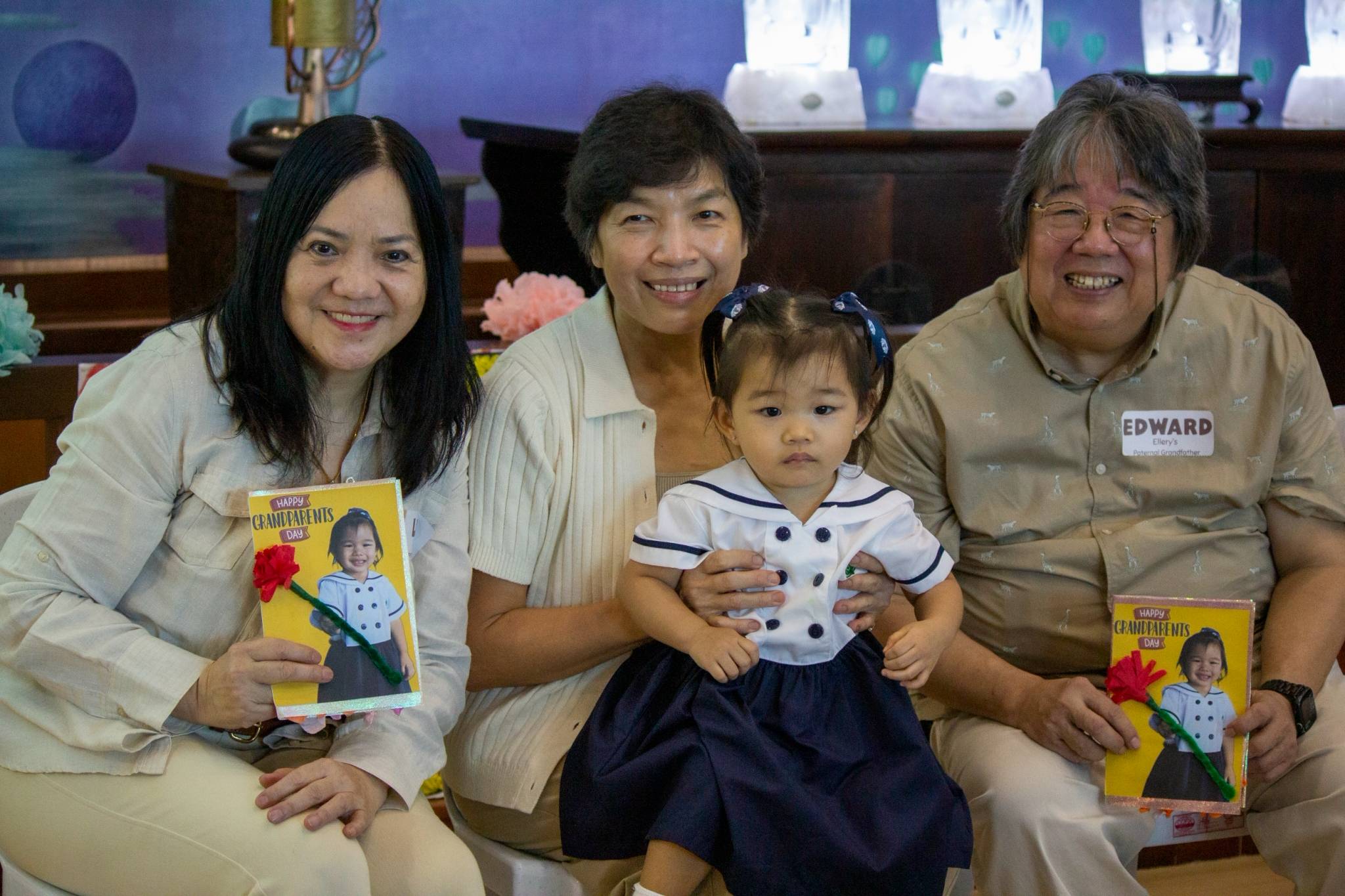 In a picture of pure love, families share warm smiles and display their special cards.