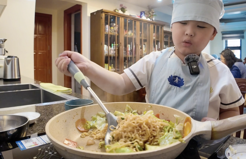 Pre-kindergarten student Gavin cooks a nutritious veggie noodle dish.