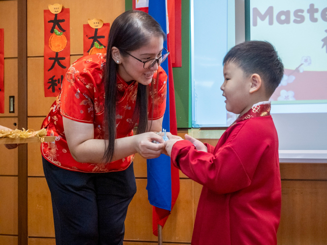 Tzu Chi Great Love Preschool Philippines Directress Jane Sy presents each preschooler with a token. 