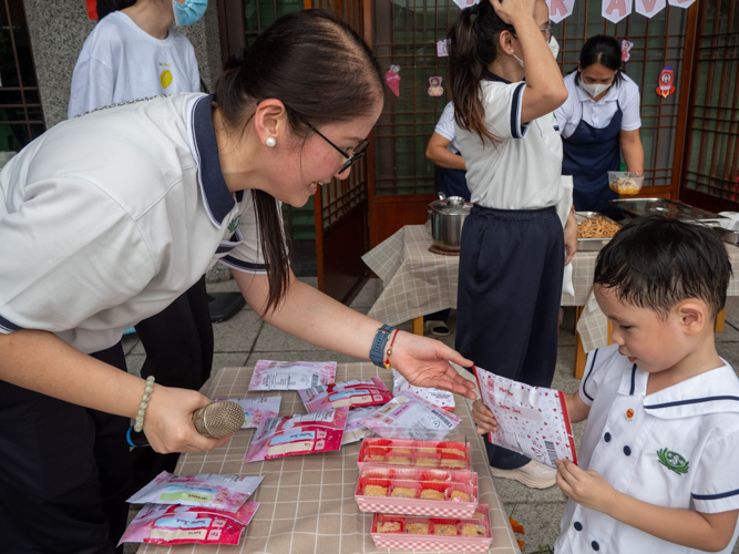 Preschool directress Jane Sy gives gifts for the students, after a successful day at the kiddie market. 