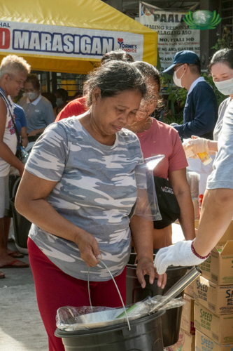 Beneficiary Marivel Cerezo receives relief goods.
