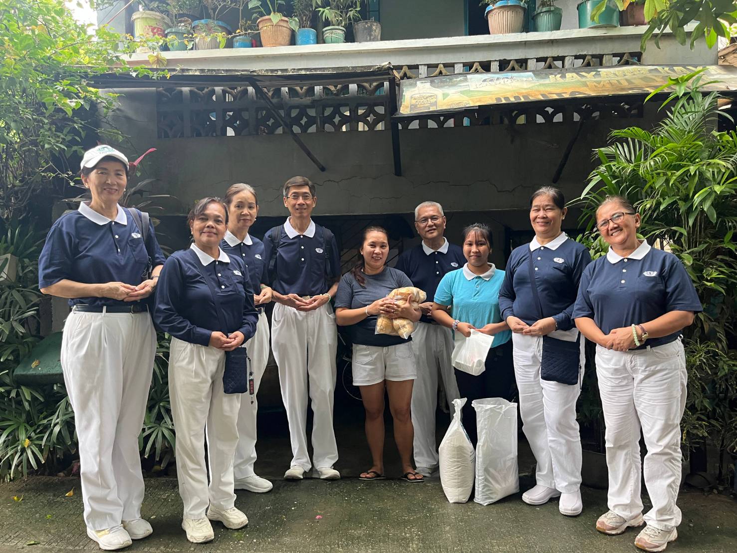 Tzu Chi scholar Haileyrain Rodrigues (third from right) accepted basic provisions and two packs of bread from volunteers.