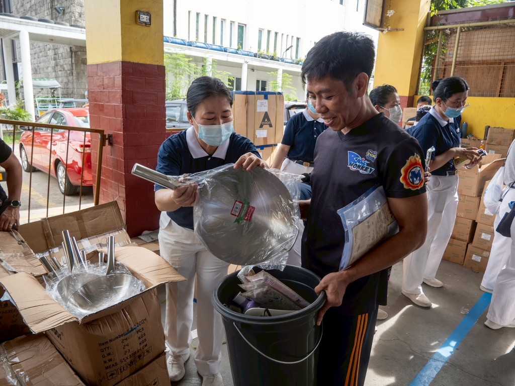 Beneficiary Manuel Docusin receives relief items.