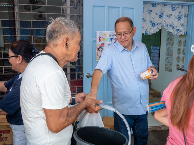 Mayor Marcy Teodoro (right) helps in distributing relief goods.